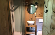 Baño en Four Season Lodge de EuroParcs Ruinen, Países Bajos, con decoración de madera y ducha.