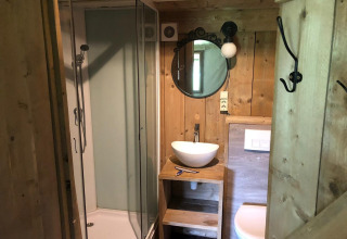 Baño en Four Season Lodge de EuroParcs Ruinen, Países Bajos, con decoración de madera y ducha.