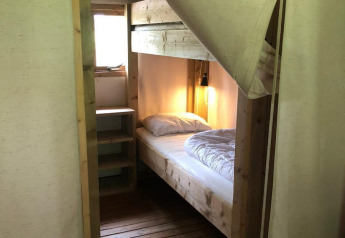 Stanza con letto singolo e pavimento in legno al Four Season Lodge, EuroParcs Ruinen, Paesi Bassi.