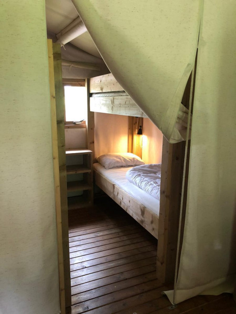 Værelse med en enkeltseng og træmøbler på Four Season Lodge, EuroParcs Ruinen, Nederlandene.