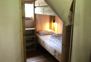 Habitación con cama individual y suelo de madera en Four Season Lodge, EuroParcs Ruinen, Países Bajos.