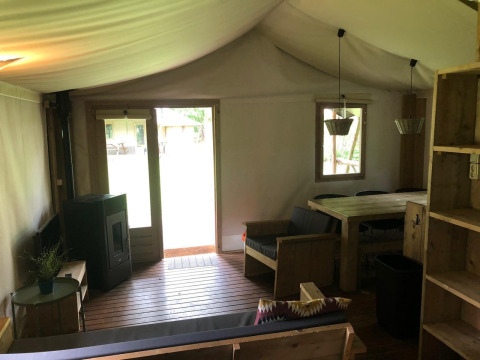 Indvendigt billede af Four Season Lodge ved EuroParcs Ruinen, med træmøbler og stort vindue til haven.