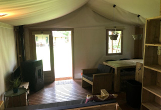 Indvendigt billede af Four Season Lodge ved EuroParcs Ruinen, med træmøbler og stort vindue til haven.