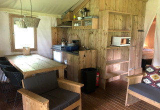 Interior view of Four Season Lodge at EuroParcs Ruinen, Netherlands, featuring wooden furniture and cozy setup.