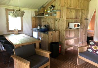 Innenaufnahme der Four Season Lodge bei EuroParcs Ruinen, Niederlande, mit gemütlicher Holzeinrichtung und Sofa.