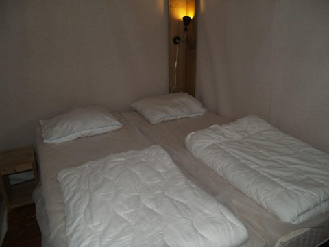 Doppelbett mit zwei einzelnen Bettdecken und Kissen im Four Season Lodge im EuroParcs Ruinen, Niederlande.