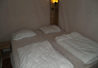 Cama doble con dos edredones individuales y almohadas en Four Season Lodge, EuroParcs Ruinen, Países Bajos.