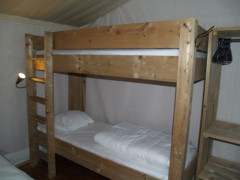 Kamer met houten stapelbed in Four Season Lodge, EuroParcs Ruinen, Nederland, met planken en kleerhangers.