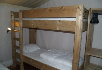 Room with wooden bunk bed at Four Season Lodge, EuroParcs Ruinen in the Netherlands, with shelves and hangers.