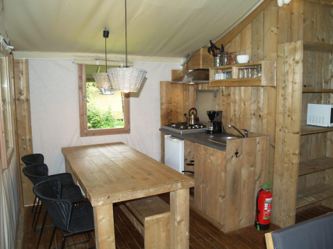 Interior de Four Season Lodge en EuroParcs Ruinen, Países Bajos, con muebles de madera y cocina pequeña.