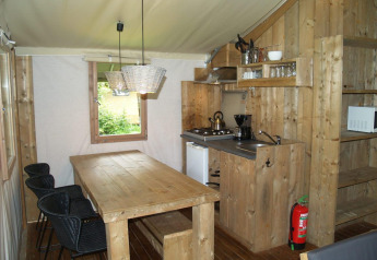 Interior de Four Season Lodge en EuroParcs Ruinen, Países Bajos, con muebles de madera y cocina pequeña.