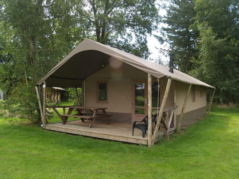 Vue extérieure de la Four Season Lodge à EuroParcs Ruinen, Pays-Bas, avec terrasse, table et pelouse verte.