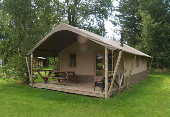 Exterior of Four Season Lodge at EuroParcs Ruinen, Netherlands, showing porch, picnic table and green lawn.