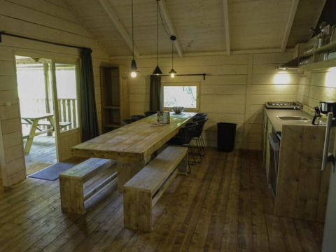 Gemütlicher Ess- und Küchenbereich aus Holz in der Glamping Family Lodge 10 bei EuroParcs Ruinen, Niederlande.