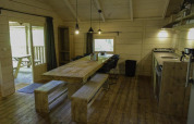 Accogliente zona pranzo e cucina in legno al Glamping Family Lodge 10 di EuroParcs Ruinen, Paesi Bassi.