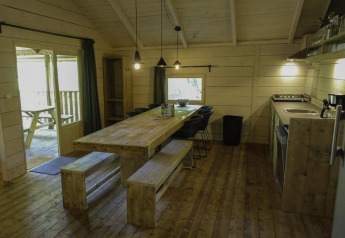 Accogliente zona pranzo e cucina in legno al Glamping Family Lodge 10 di EuroParcs Ruinen, Paesi Bassi.