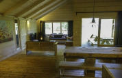 Helles Holzinterieur der Glamping Family Lodge 10 bei EuroParcs Ruinen mit großen Fenstern und Holzmöbeln.