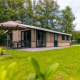 Udendørsbillede af Hackfort-chalet med terrasse, parasol og grønne omgivelser i naturskønt område.