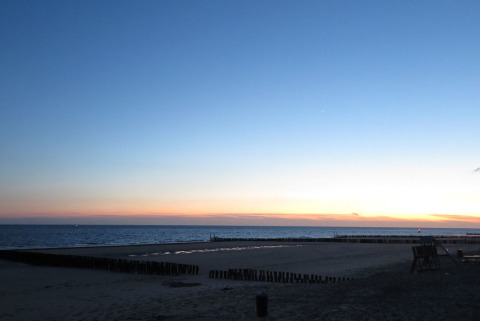 Atardecer en la playa junto a Beach house 'Dishoek 60', Dishoek, Zeeland, Países Bajos, con mar tranquilo.