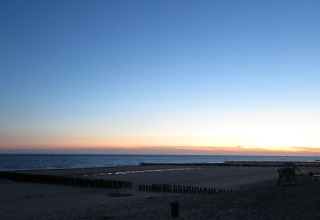 Coucher de soleil sur la plage au Beach house 'Dishoek 60', Dishoek, Zélande, Pays-Bas, avec mer calme.