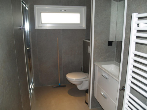 Salle de bain moderne du chalet Hackfort à EuroParcs Ruinen, Pays-Bas, avec WC suspendu et douche.