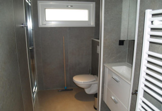 Bagno moderno del chalet Hackfort a EuroParcs Ruinen, Paesi Bassi, con WC sospeso e doccia.
