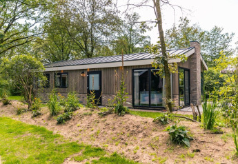 Buitenaanzicht van het Hackfort-chalet bij EuroParcs Ruinen in Nederland, omgeven door groene natuur.