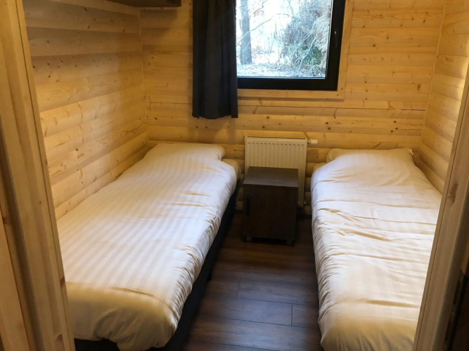 Zwei Einzelbetten in einem Holzraum der Velthorst-Lodge im Vakantiepark De Wiltzangh, Niederlande.