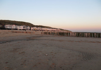 Strandhäuser bei Sonnenuntergang am ruhigen Strand von Dishoek 60, Zeeland, Niederlande.