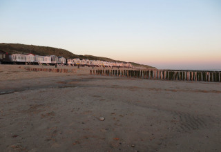 Casas de playa frente al mar y dunas al atardecer en Dishoek 60, Zeeland, Países Bajos.