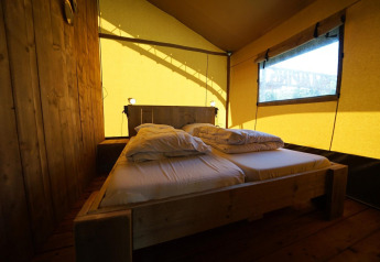 Indenfor en Safari-telt lodge på Molengroet i Holland, vises en dobbeltseng og træinteriør.