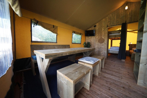 Vista interna della tenda Safari al Molengroet nei Paesi Bassi con mobili in legno e atmosfera accogliente.