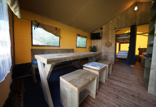 Vista interna della tenda Safari al Molengroet nei Paesi Bassi con mobili in legno e atmosfera accogliente.