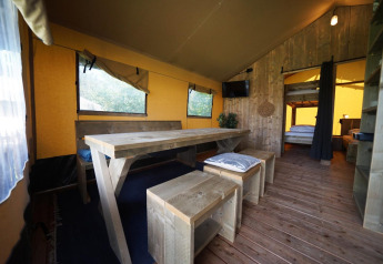 Interieur van een Safaritent bij Molengroet in Nederland met houten meubels en een gezellige sfeer.