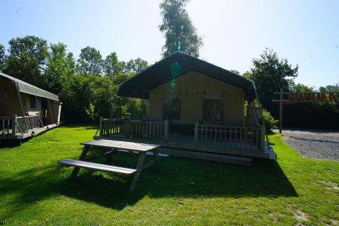 Tente safari au Molengroet aux Pays-Bas avec terrasse en bois, table de pique-nique et pelouse.