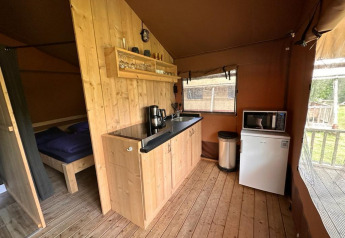 Indvendigt billede af Glampingtent Desert på Molengroet, Holland, med tekøkken og soveværelse.