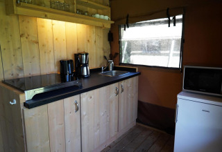 Cocina en Glampingtent Desert en Molengroet, Países Bajos, con estufa, fregadero y cafetera.
