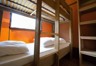 Una habitación con literas y estanterías en la Glampingtent Desert de Molengroet, Países Bajos.
