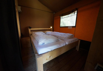 Et interiørbillede af et soveværelse i Glampingtent Desert ved Molengroet, Holland, med en dobbeltseng.