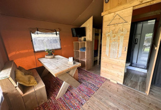Vista interior de Glampingtent Desert en Molengroet, Países Bajos, con muebles rústicos y decoración moderna.