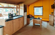 Interior de Glampingtent Dreamer en Molengroet, Países Bajos, con zona de estar acogedora y cocina pequeña.