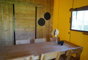 Wooden table with chairs and decorative items in Glampingtent Dreamer lodge at Molengroet, Netherlands