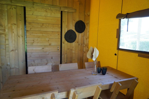 Houten tafel met stoelen en decoratie in Glampingtent Dreamer bij Molengroet, Nederland