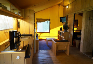 Indvendigt billede af Glampingtent Dreamer-lodgen på Molengroet i Holland med træinteriør og køkken.