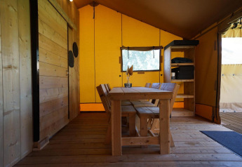 Vista interior de Glampingtent Dreamer en Molengroet, Países Bajos, con mobiliario de madera.