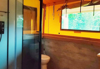 Bathroom inside Glampingtent Kompact at Molengroet, Netherlands, featuring shower, toilet, sink, and window.