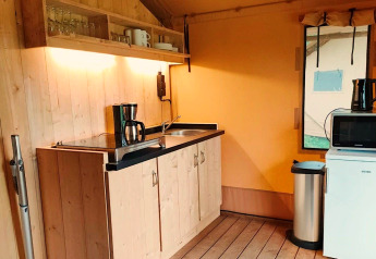 Køkkenområde i Glampingtent Kompact ved Molengroet, Holland, med vask, kaffemaskine og mikrobølgeovn.