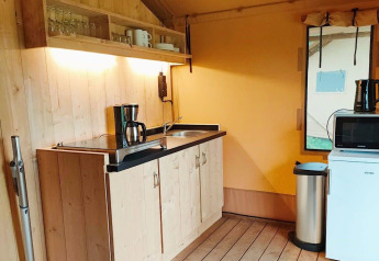 Køkkenområde i Glampingtent Kompact ved Molengroet, Holland, med vask, kaffemaskine og mikrobølgeovn.