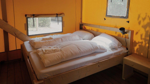 Indvendigt af Glampingtent Sunshine ved Molengroet i Holland med to senge og naturligt lys.