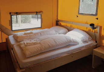 Intérieur de la tente Glampingtent Sunshine à Molengroet, Pays-Bas, avec deux lits simples.